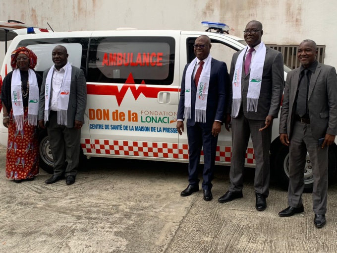 Le directeur exécutif de la Fondation Lonaci remettant les clés de l'ambulance au président de l'Unjci